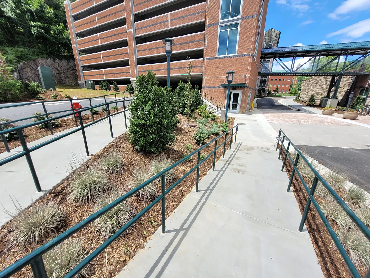 Landscape architecture incorporated along pedestrian pathways connects the new parking deck to existing campus aesthetics.